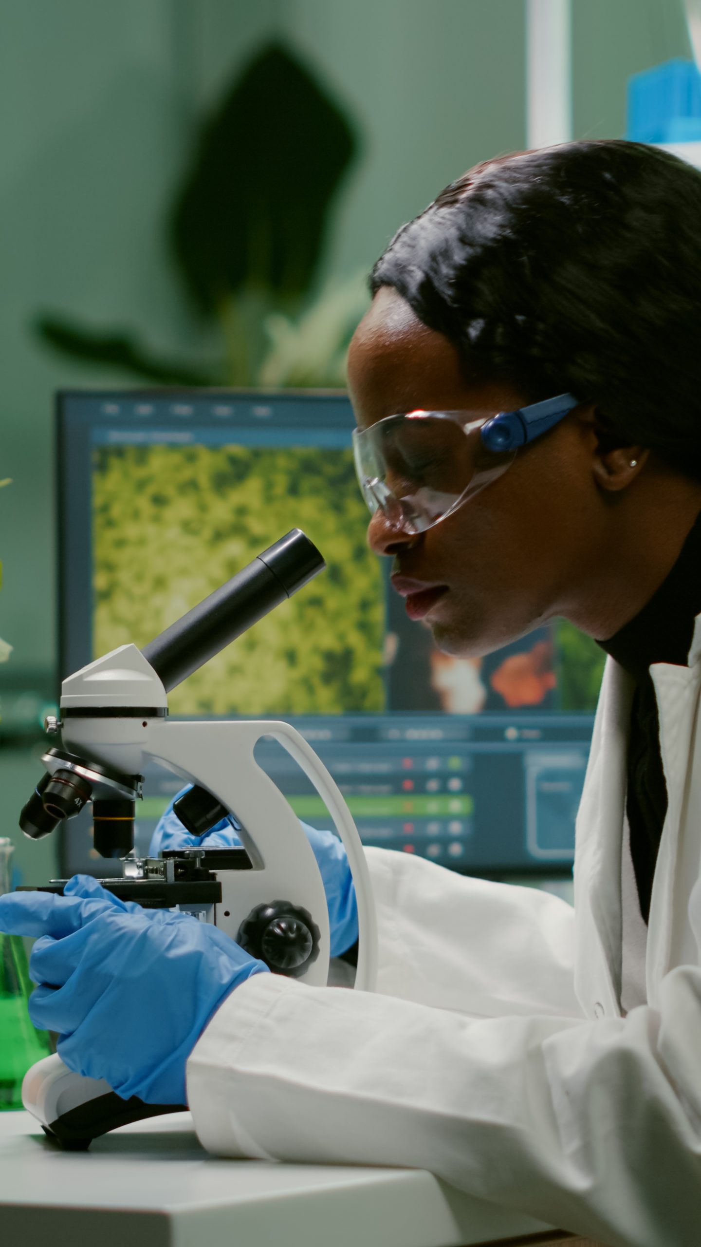 biologist woman looking at test sample under microscope